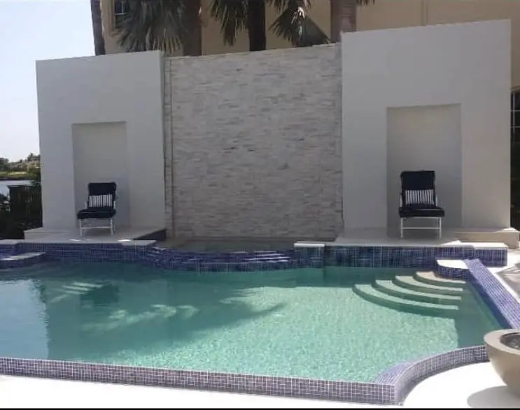 Modern pool with feature wall, Glass tile waterline, wide entry steps