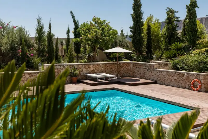 Courtyard pool with stone wall, Wood deck, shade-friendly planting